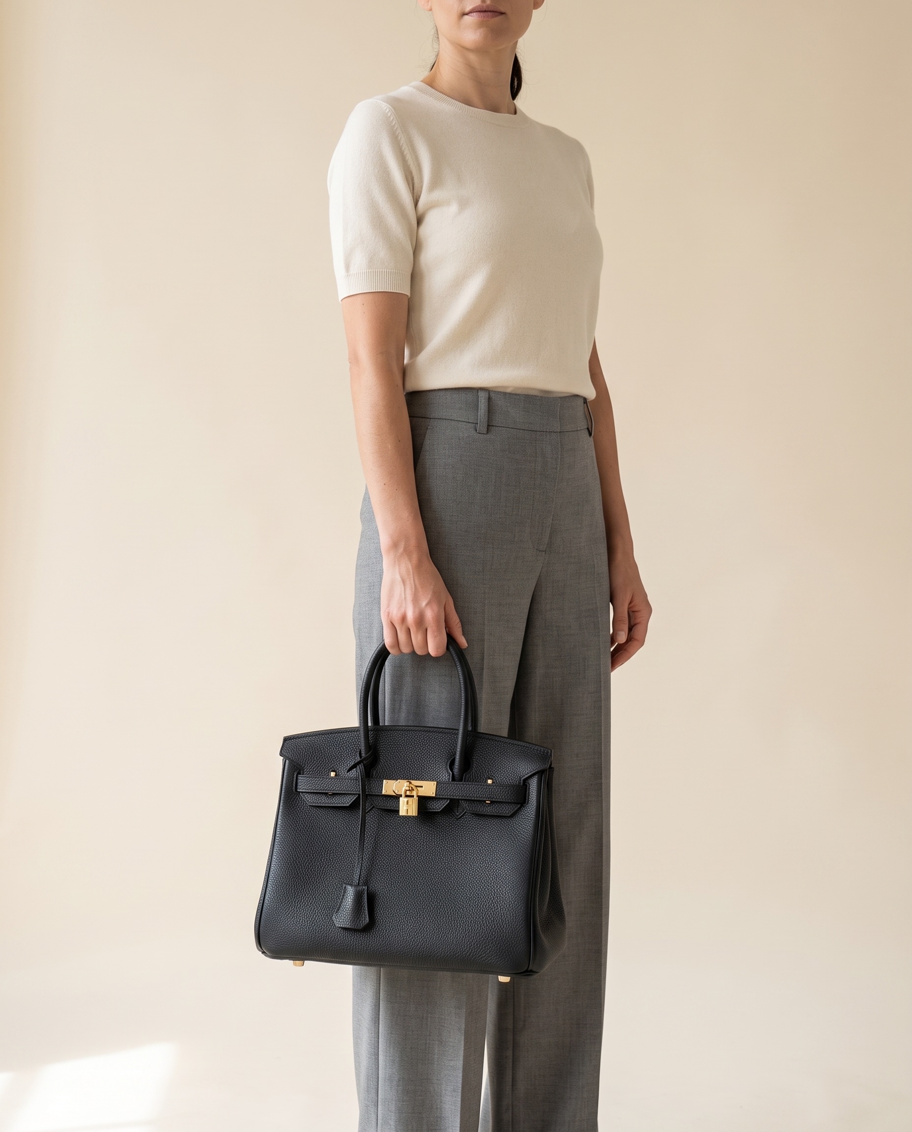 A woman holding the Madrid 30 in Noir at her side, showing its scale against her body
